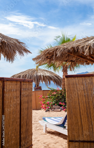 beach umbrella of palm branches against the blue sky