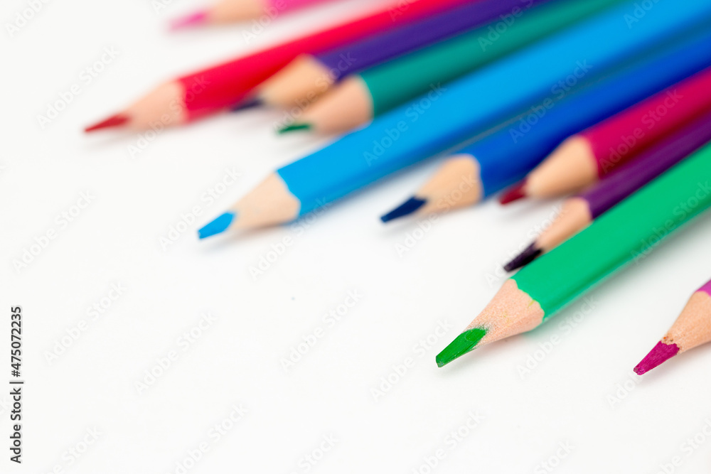 School stationery items. Creation Multicolored pencils on a blank white sheet. On a white background. Children's drawing, artist. School stationery items. Creation Multicolored pencils on a blank white sheet. On a white background. Children's drawing, artist.