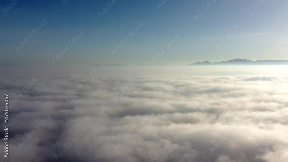 Aerial bird view moving low above the clouds flight backwards away from bright sun and crisp blue sky showing thick clouds beneath beautiful sky and amazing background contrast below sky atmosphere Aerial bird view moving low above the clouds flight backwards away from bright sun and crisp blue sky showing thick clouds beneath beautiful sky and amazing background contrast below sky atmosphere