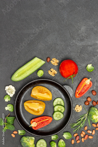 Chopped tomatoes, cucumbers and peppers in frying pan.