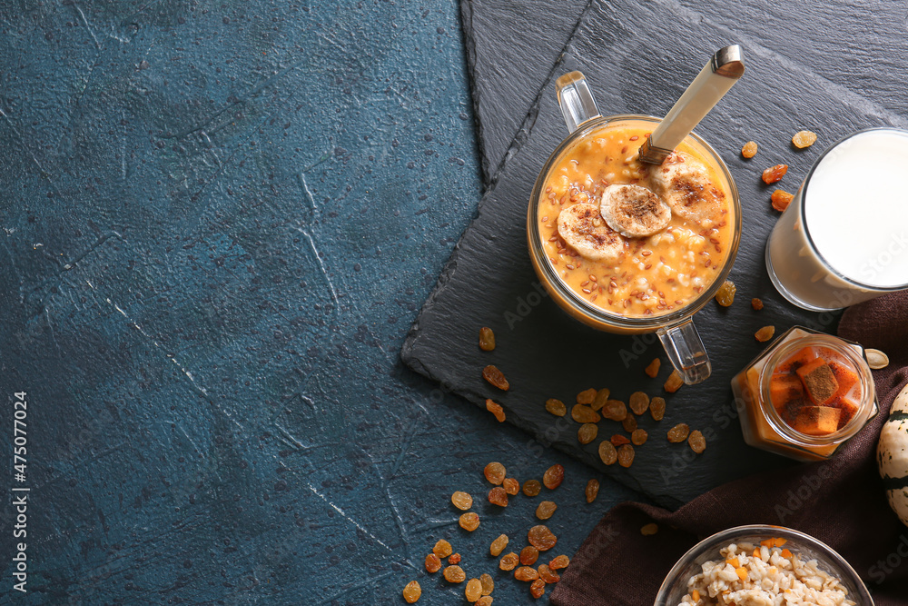 Pot of tasty oatmeal with pumpkin on black background Pot of tasty oatmeal with pumpkin on black background