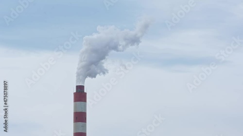 Factory chimney with smoke coming out. Factory pipe pollutes the air in an industrial area.