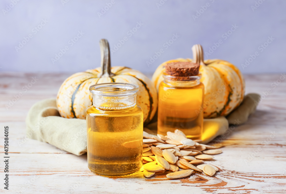 Obraz premium Bottles with pumpkin seed oil on table