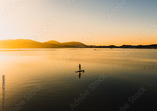 Practicing stand up pandle at sunrise at Lagoa da Conceição in Florianópolis Santa Catarina Brazil © Lucas