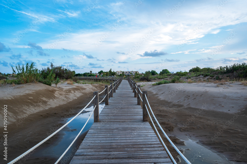 Landscape with wooden walkway in the sand on the beach Landscape with wooden walkway in the sand on the beach