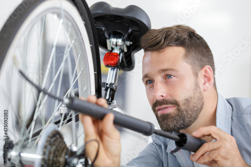 man pumping up a bike tire using small pump