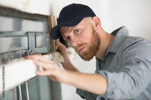 Photos builder inspectiing damaged window lintel