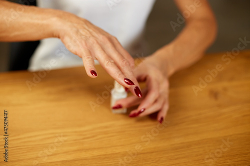 Close up Senior woman applying polish on nails at home