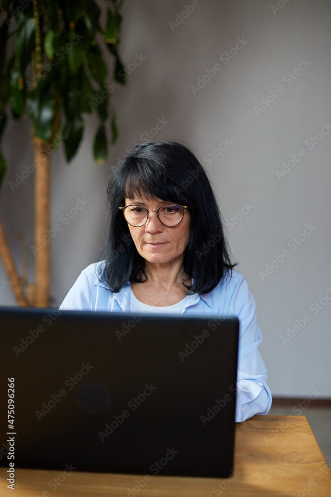 Senior woman in eyeglasses typing on laptop messaging, chatting Senior woman in eyeglasses typing on laptop messaging, chatting