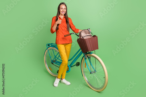 Fototapeta Naklejka Na Ścianę i Meble -  Full body photo of pretty young lady show thumb-up select suggest ads rider isolated over green color background