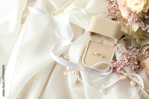 Concept of wedding accessories with wedding ring, close up