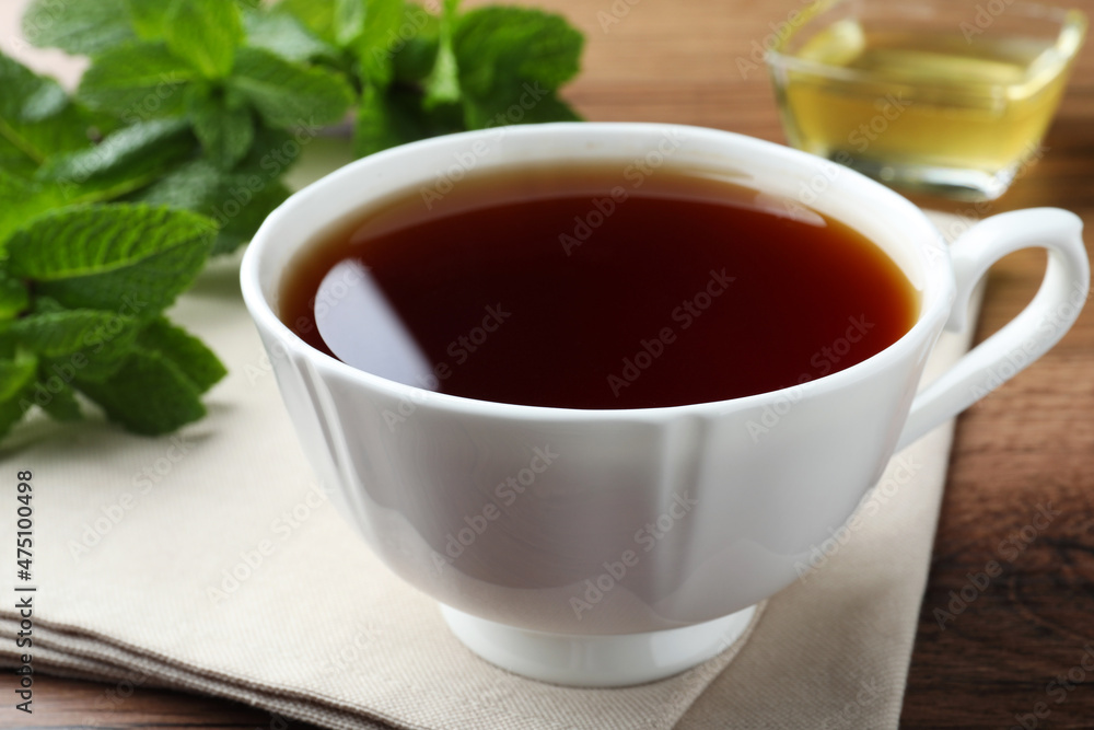 Cup of hot aromatic tea with mint on wooden table, closeup Cup of hot aromatic tea with mint on wooden table, closeup