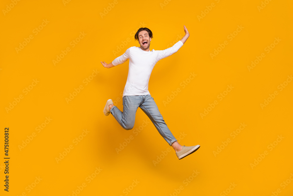Full body photo of scared brunet young guy run wear shirt jeans sneakers isolated on yellow background