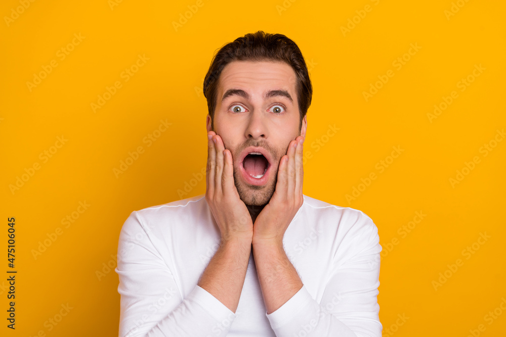 Photo of millennial impressed brunet guy open mouth wear white shirt isolated on bright yellow color background Photo of millennial impressed brunet guy open mouth wear white shirt isolated on bright yellow color background