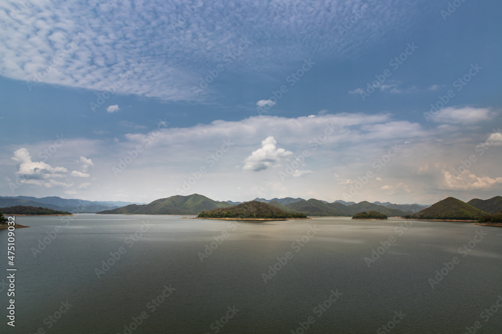 View of lake shore with mountains range in background at sunrise or sunset. No focus, specifically.