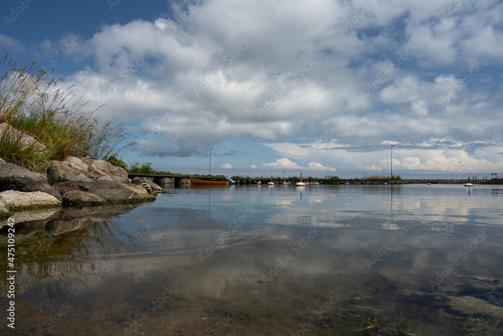 A blue sky with patchy clouds over a calm bay in the summertime. From the Swedish island Oland A blue sky with patchy clouds over a calm bay in the summertime. From the Swedish island Oland