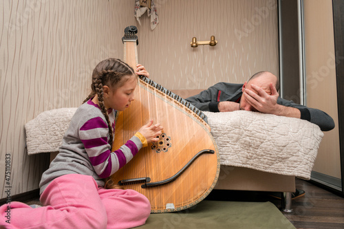 Картината върху платно The child plays the bandura, and the man holds his head with his hand