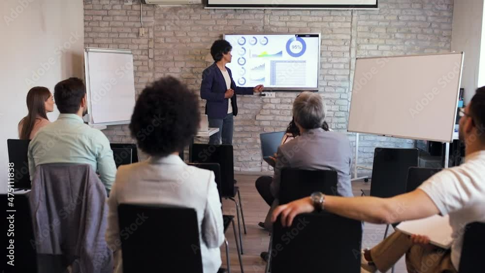 Business man holding presentation to diverse group of people.