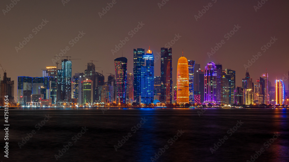 Fototapeta premium view of doha corniche during night along with fanar building.