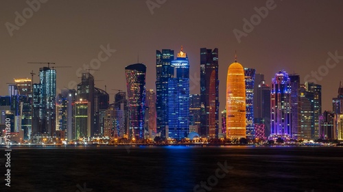 view of doha corniche during night along with fanar building.