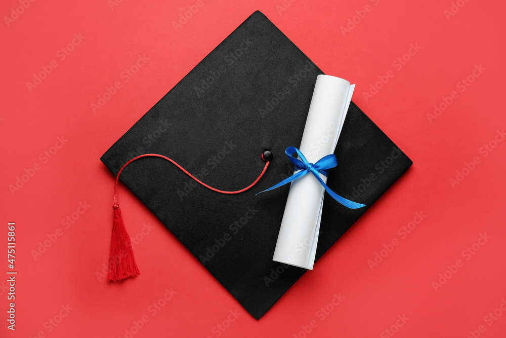 Graduation hat and diploma on red background, top view Stock Photo