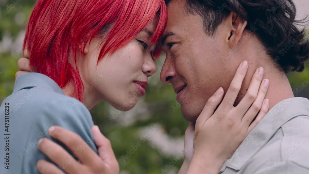 Asian couple standing face to face and hugging on street Asian couple standing face to face and hugging on street