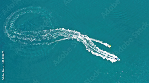 Aerial drone photo of extreme powerboat donut water-sports cruising in high speed in tropical turquoise bay