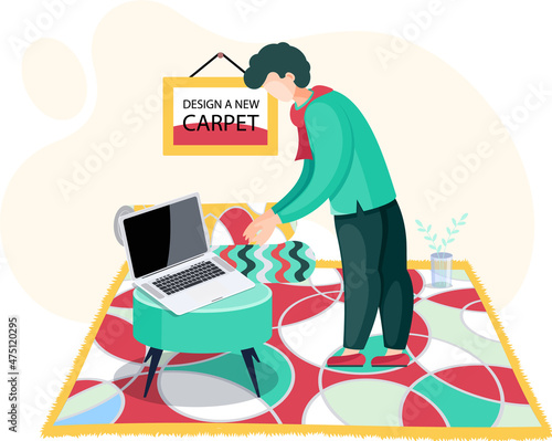 Male designer works at table with computer in room interior with geometric pattern rug, engaged in design of carpets. Buyer orders carpet from home textile store. Shop for selling floor coverings