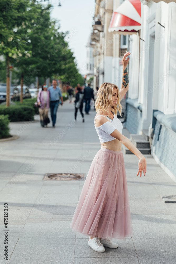 beautiful woman dancing to music on the street of the city