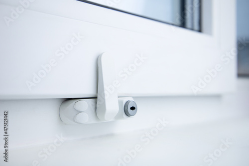Child safety lock on a window frame an apartment . Security lock for windows ensures the safety of your children and prevents accidents.Prevention of falling accident