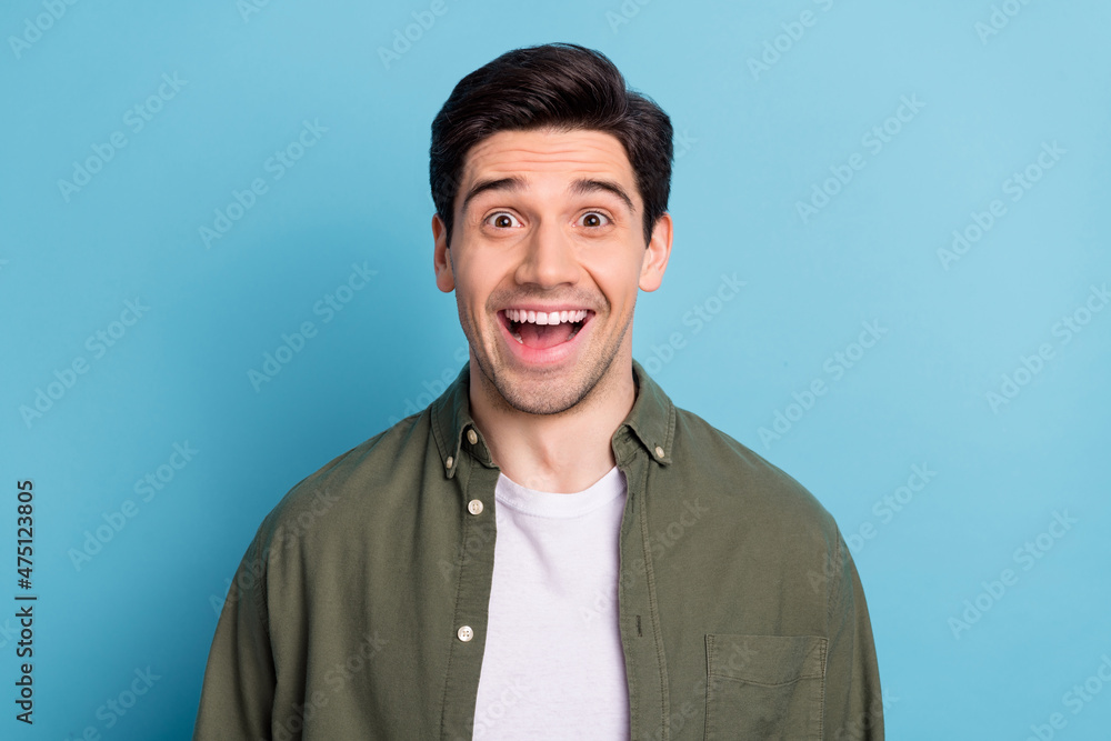 Portrait of astonished guy hear wonderful message scream open mouth isolated on blue color background Portrait of astonished guy hear wonderful message scream open mouth isolated on blue color background