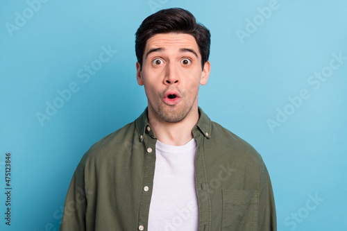 Portrait of impressed guy look open mouth amazing message isolated over sky light color background © deagreez