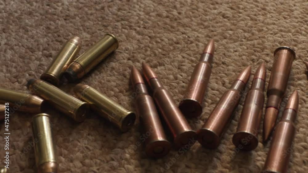 rifle cartridges close-up on the carpet. smooth camera movement rifle cartridges close-up on the carpet. smooth camera movement