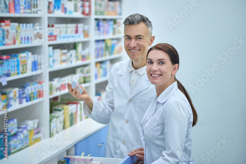 Two druggists in lab coats in the process of inventory in a drugstore © zinkevych