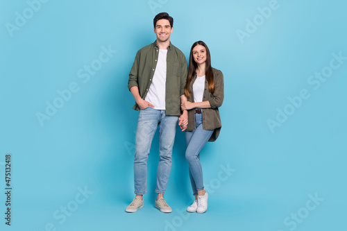 Full length photo of affectionate soulmate lady hold hand guy cuddle date wear denim jeans isolated over blue color background