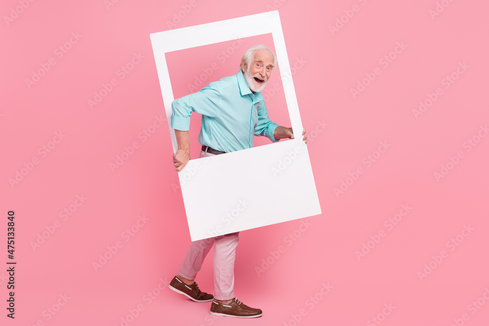Full size profile side photo of energetic middle age man hold photograph border step away isolated pastel color background Full size profile side photo of energetic middle age man hold photograph border step away isolated pastel color background