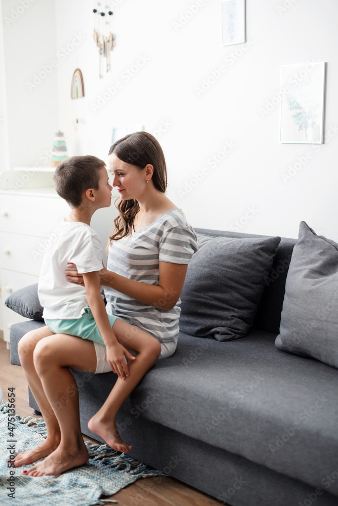 Cute funny child son embracing mother holding tight feeling love