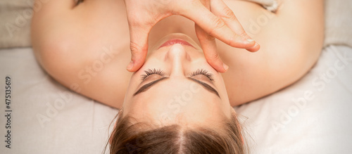 Face massage with fingers of a masseur. Female facial skin care at a beauty spa salon