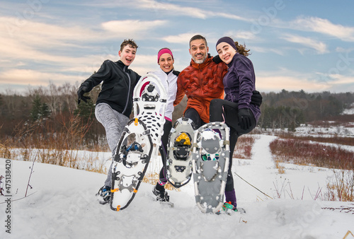 family hiking with snowshoes racket in winter day photo