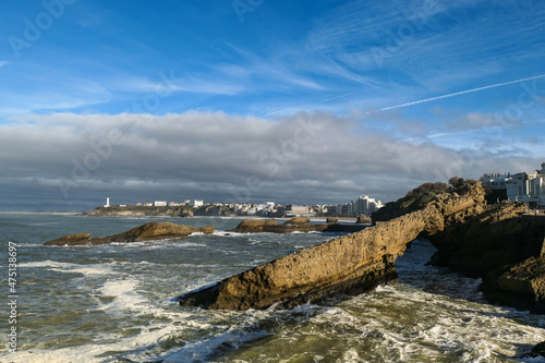 Cidade de Biarritz com a praia e um farol ao fundo à esquerda no país Basco francês photo