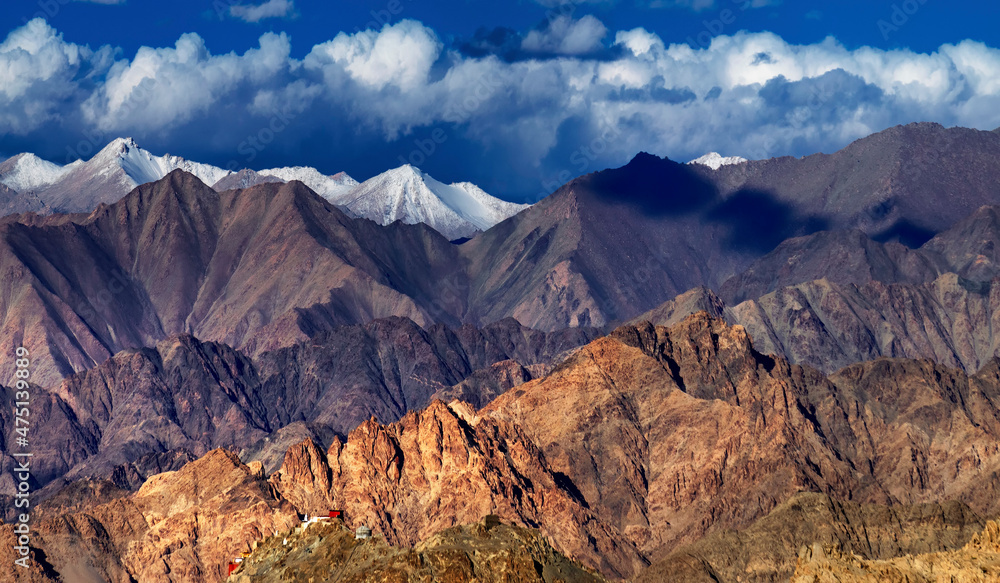 Panoramic rocky landscape of Leh City with ice peaks in background , blue sky with clouds, Ladakh, Jammu and Kashmir, India