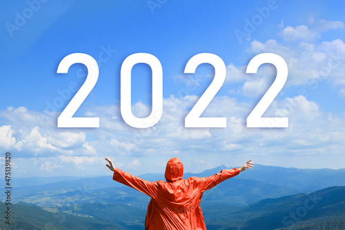 New year concept of 2022. Adventure traveler woman raising hands on the top of mountain scenery. Planning and challenge, business strategy, opportunity ,hope, new life change