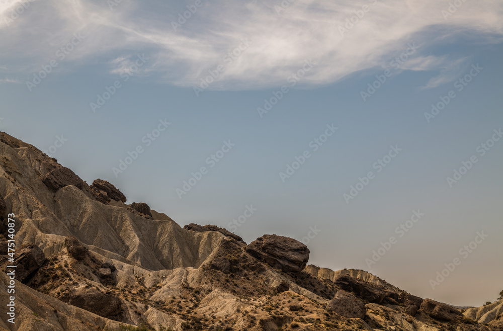 Obraz premium Landscape of mountain in desert of Almeria, Spain, against cloudy blue sky
