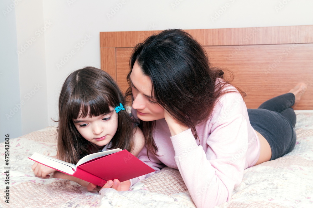 Mom with the daughter reading together Mom with the daughter reading together