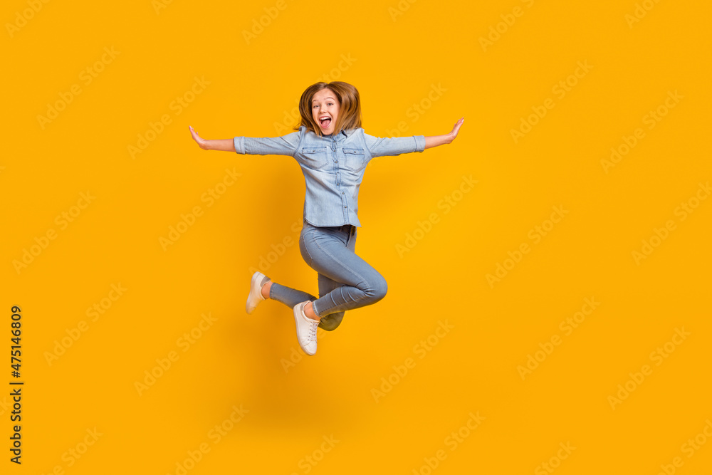 Full body photo of hooray teenager girl jump yell wear bag jeans shirt sneakers isolated on yellow background
