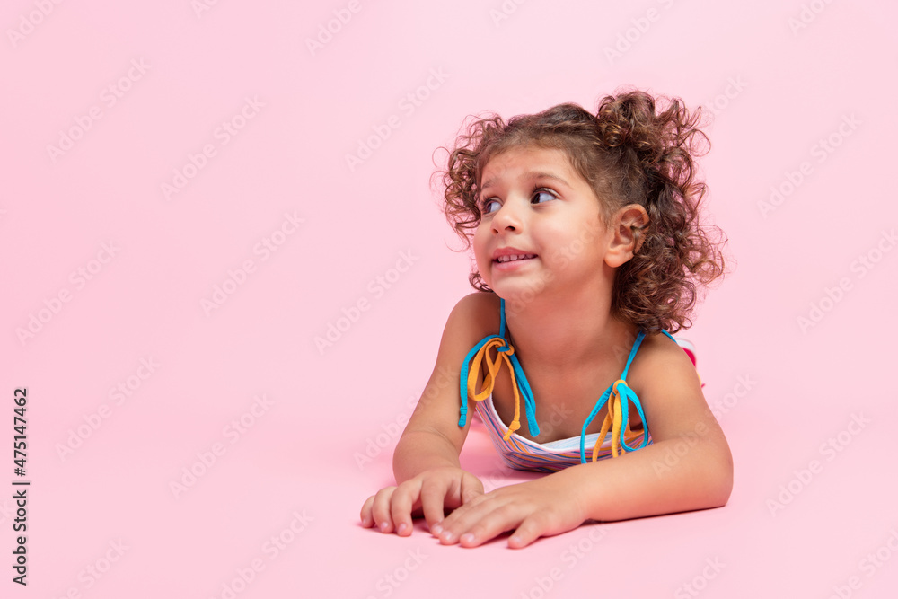 Portrait of attractive cheerful wavy-haired girl lying on floor thinking copy space isolated over pink pastel color background Portrait of attractive cheerful wavy-haired girl lying on floor thinking copy space isolated over pink pastel color background
