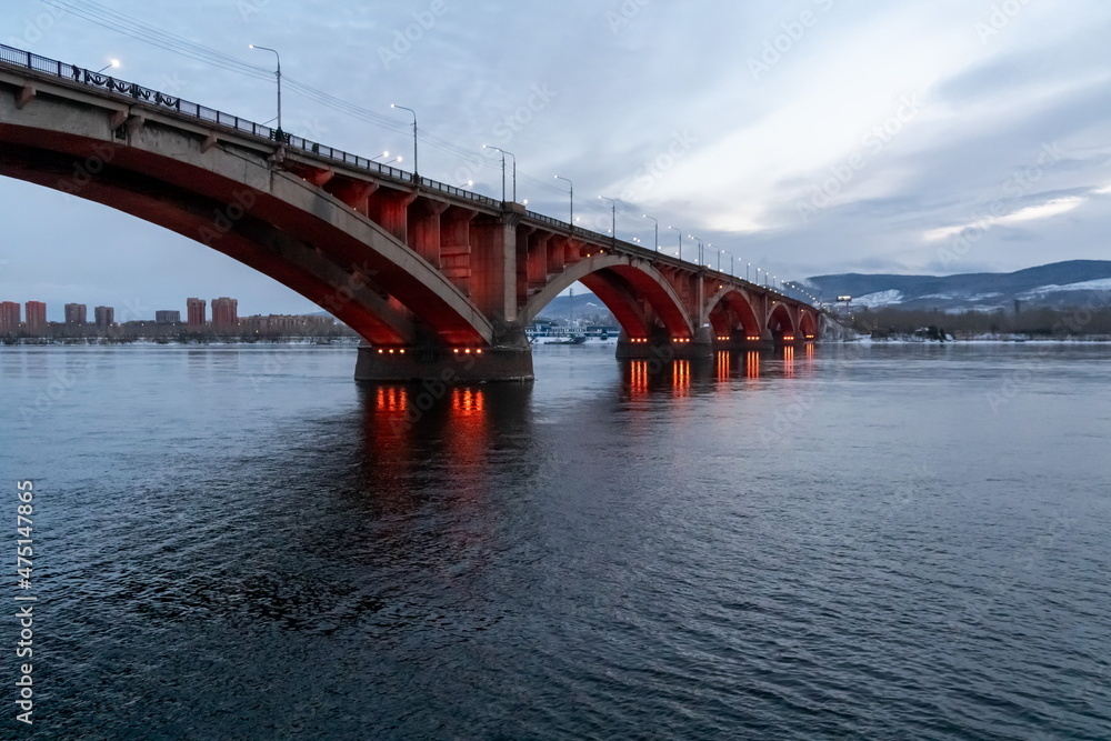 Communal Bridge (1961) with night illumination across the Yenisei River in the city of Krasnoyarsk. Russia.