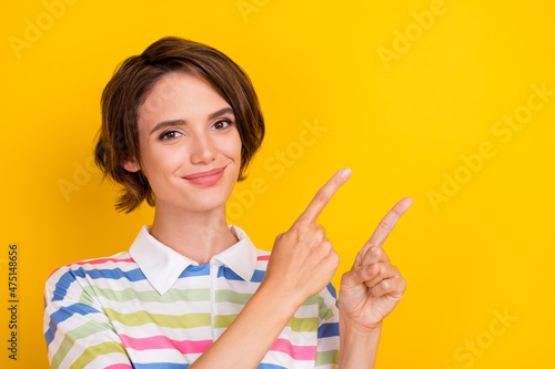 Photo of nice millennial brunette lady point empty space wear sriped t-shirt isolated on yellow color background