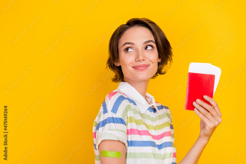 Photo of funky millennial brunette lady with plaster show passport look wear white t-shirt isolated on yellow color background Photo of funky millennial brunette lady with plaster show passport look wear white t-shirt isolated on yellow color background