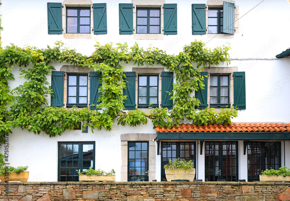 Fototapeta premium fachada de casa con ventanas verdes en ascain pueblo vasco francés francia 4M0A7741-as21